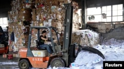 A laborer works at a paper products recycling station in Shanghai, China, Nov. 17, 2017.