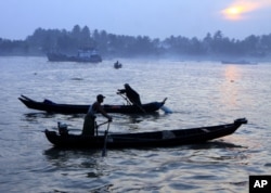 In this photo taken on Friday, Feb. 17, 2012, boatmen cross a river in Pyar Pon, Irrawaddy Delta, about 80 kilometers (50 miles) south of Yangon, Myanmar.