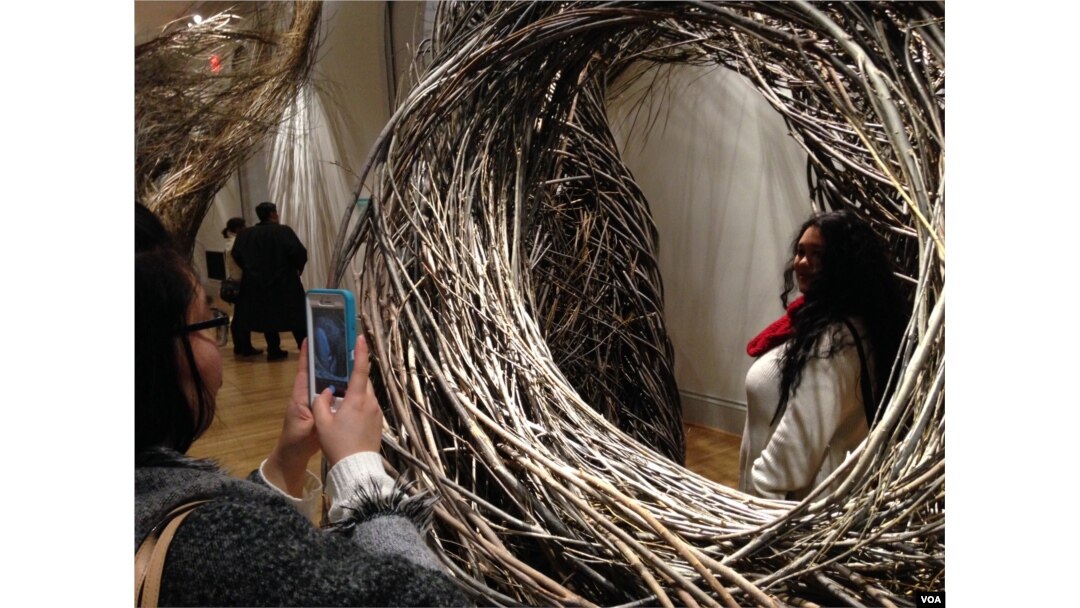 Jessica Liou takes a picture of fellow museum visitor Megan Limson at the WONDER exhibit, Renwick Gallery, Washington. (J. Taboh/VOA)