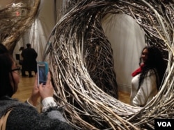 Jessica Liou takes a picture of fellow museum visitor Megan Limson at the WONDER exhibit, Renwick Gallery, Washington. (J. Taboh/VOA)