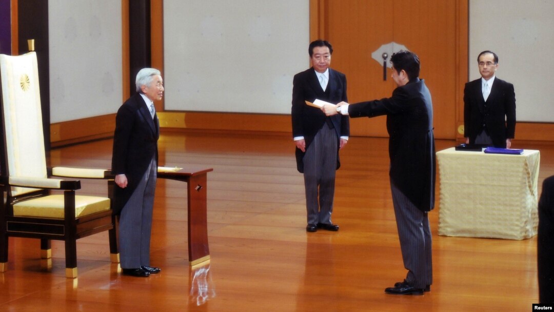 PM baru Jeoang, Shinzo Abe (dua dari kanan) menerima sebuah sertifikat dari Kaisar Akihito (kiri), diawasi oleh mantan PM Yoshihiko Noda (dua dari kiri) dalam upacara pelantikan PM Jepang di Istana Kekaisaran Jepang di Tokyo (26/12).