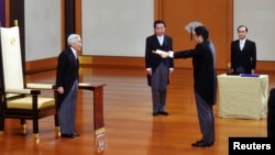 PM baru Jeoang, Shinzo Abe (dua dari kanan) menerima sebuah sertifikat dari Kaisar Akihito (kiri), diawasi oleh mantan PM Yoshihiko Noda (dua dari kiri) dalam upacara pelantikan PM Jepang di Istana Kekaisaran Jepang di Tokyo (26/12).