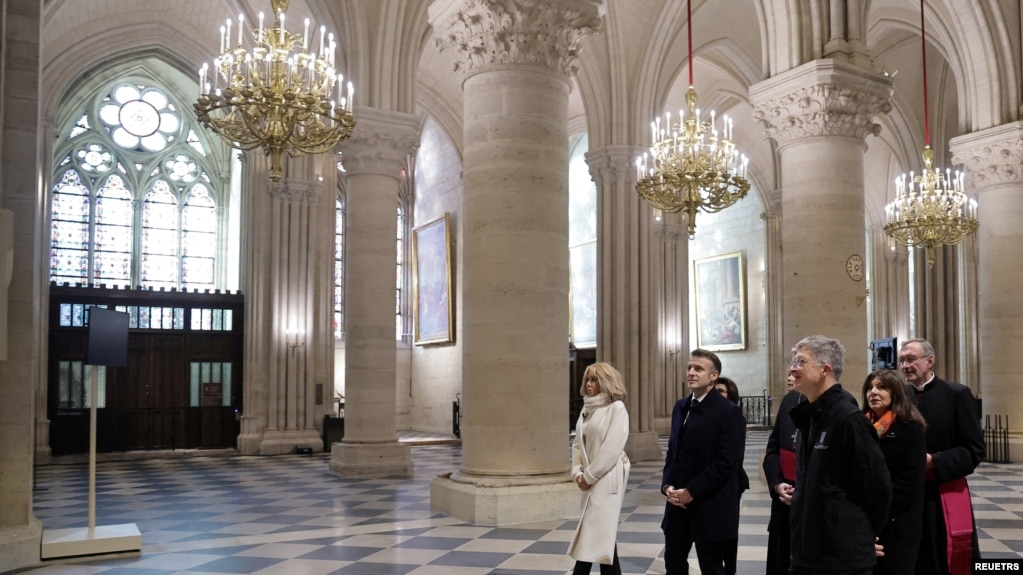 Tổng thống Pháp Emmanuel Macron (giữa) và Đệ nhất phu nhân Brigitte Macron (trái) trong chuyến thăm Nhà thờ Đức Bà Paris hôm 29/11/2024, để cảm ơn các nhà tài trợ và những người đã làm việc phục dựng nhà thờ sau vụ hỏa hoạn ngày 15/4/2019.