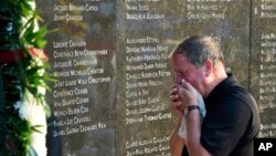 Chris Rhoads, who was the General Manager of Flight Attendants for TWA, reacts at the memorial wall during the 20th anniversary of the TWA Flight 800 plane crash at Smith Point County Park on Sunday, July 17, 2016, in Shirley, N.Y. 