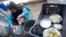 A Syrian refugee washes dishes at a camp in Tyre, Lebanon, Jan. 31, 2013. 