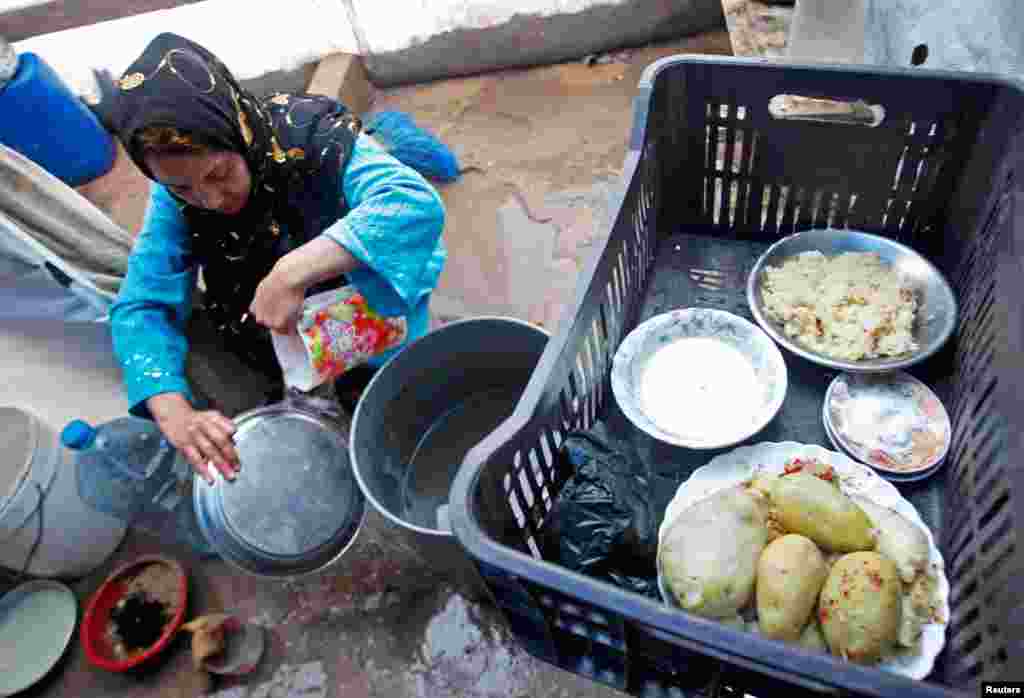 Seorang pengungsi Suriah mencuci piring di sebuah kamp di Tyre, Lebanon. (Reuters/Ali Hashisho)