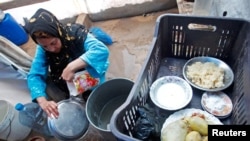 A Syrian refugee washes dishes at a camp in Tyre, Lebanon, Jan. 31, 2013. 