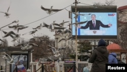 Russian President Vladimir Putin is seen on a screen during his annual address to the Federal Assembly. Taken in Sevastopol, Crimea, Occupied Ukraine. Feb. 21, 2023