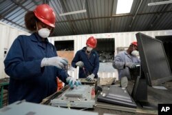 FILE—Employees dismantle laptop waste at WEEE center recycling plant, a collection point where people can deposit old electric equipment in Nairobi, Kenya, March. 20, 2024.