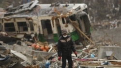 A man searches for a family member in the ruins of a tsunami-hit area in Onagawa, Miyagi Prefecture, Japan