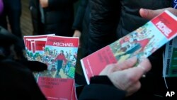 FILE - Brenda Jenkyns who drove from Calgary, Canada hands out pamphlets in support of Michael Jackson outside of the premiere of the "Leaving Neverland" Michael Jackson documentary film at the Egyptian Theatre on Main Street during the 2019 Sundance Film Festival, Jan. 25, 2019,