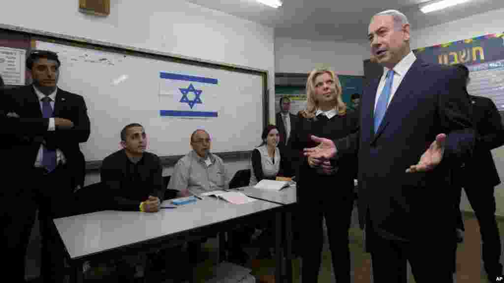 Le Premier ministre israélien, Benjamin Netanyahu, débout avec sa femme Sara, s'entretient avec la presse après avoir voté aux élections législatives d'Israël à Jérusalem, le 17 mars 2015.