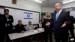 Israeli Prime Minister Benjamin Netanyahu stands with his wife Sara as he speaks to the media, after voting in Israel's parliamentary elections in Jerusalem, Tuesday, Mar. 17, 2015. 