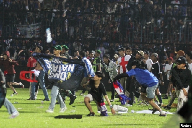 Para suporter Arema FC memasuki lapangan setelah tim mereka kalah dari Persebaya usai pertandingan di Stadion Kanjuruhan, 1 Oktober 2022 (foto: dok).