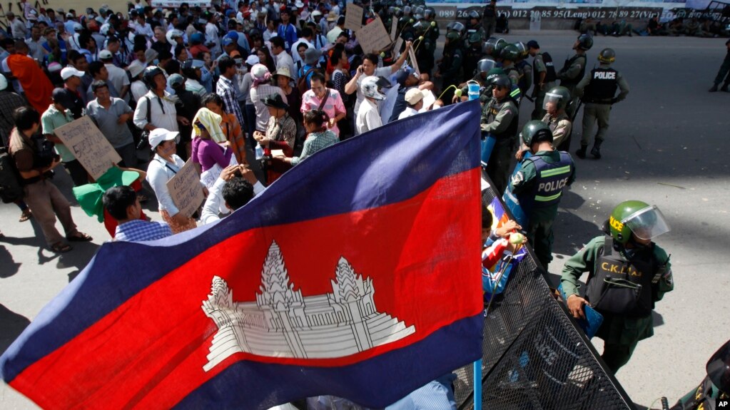 រូបឯកសារ៖ បាតុករប្រមូលផ្តុំគ្នានៅមុខកងកម្លាំងប៉ូលិសបាំងដោយរនាំងដែកនៅកណ្តាលផ្លូវក្បែរតុលាការក្រុងភ្នំពេញ នៅរាជធានីភ្នំពេញ កាលពីថ្ងៃពុធ ទី១៦ ខែកក្កដា ឆ្នាំ២០១៤។