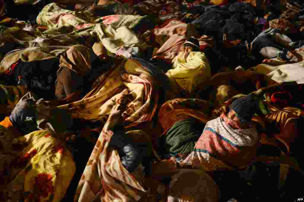 Supporters of moderate preacher Tahir-ul Qadri rest on the third day of a protest rally in Islamabad, Pakistan. Protesters call on the government to quit after the Supreme Court ordered the arrest of the prime minister.
