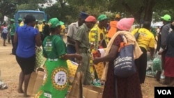 Zanu PF members receiving party regalia before a Mnangagwa rally at Murombedzi in Mashonaland West.