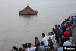 People watch a submerged pavilion in the flooded Yangtze River in Wuhan, Hubei province, July 7, 2016.