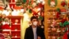 Seorang pria mengenakan masker di dalam sebuah toko ketika pemerintah Italia memaparkan rencana untuk vaksinasi massal Covid-19 dan pembatasan-pembatasan selama masa Natal, di Roma, Italia, 2 Desember 2020. (Foto: Reuters)