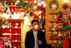 Seorang pria mengenakan masker saat berbelanja di sebuah toko menjelang Natal, di Roma, Italia, 2 Desember 2020. (Foto: Reuters)