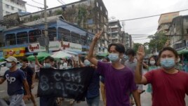 Anti-coup protesters flash the three-finger salute during a demonstration against the military takeover, in Yangon, Myanmar, Monday, May 24, 2021. (AP Photo)
