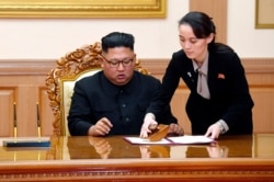 FILE - Kim Yo Jong, right, sister of North Korean leader Kim Jong Un, helps Kim sign joint statement following the summit with South Korean President Moon Jae-in at the Paekhwawon State Guesthouse in Pyongyang, Sept. 19, 2018.
