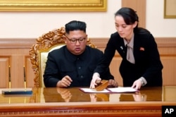 FILE - Kim Yo Jong, right, sister of North Korean leader Kim Jong Un, helps Kim sign joint statement following the summit with South Korean President Moon Jae-in at the Paekhwawon State Guesthouse in Pyongyang, Sept. 19, 2018.