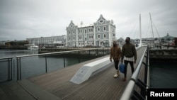 Para pengunjung mengenakan masker di distrik populer, Waterfront, yang biasanya dipadati oleh turis asing, di tengah pandemi virus corona (Covid-19) di Cape Town, Afrika Selatan, 25 Agustus 2020. (Foto: Reuters)