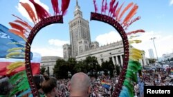 FILE - People take part in the annual Equality Parade in front of the Palace of Culture and Science in Warsaw, Poland, June 11, 2016.