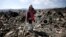 FILE - A firefighter is seen talking on a mobile phone in an earthquake and tsunami devastated area in Rikuzentakata, Iwate Prefecture, northern Japan, April 1, 2011.