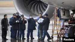 Un investigador japonés carga una batería retirada de uno de los aviones Dreamliner.