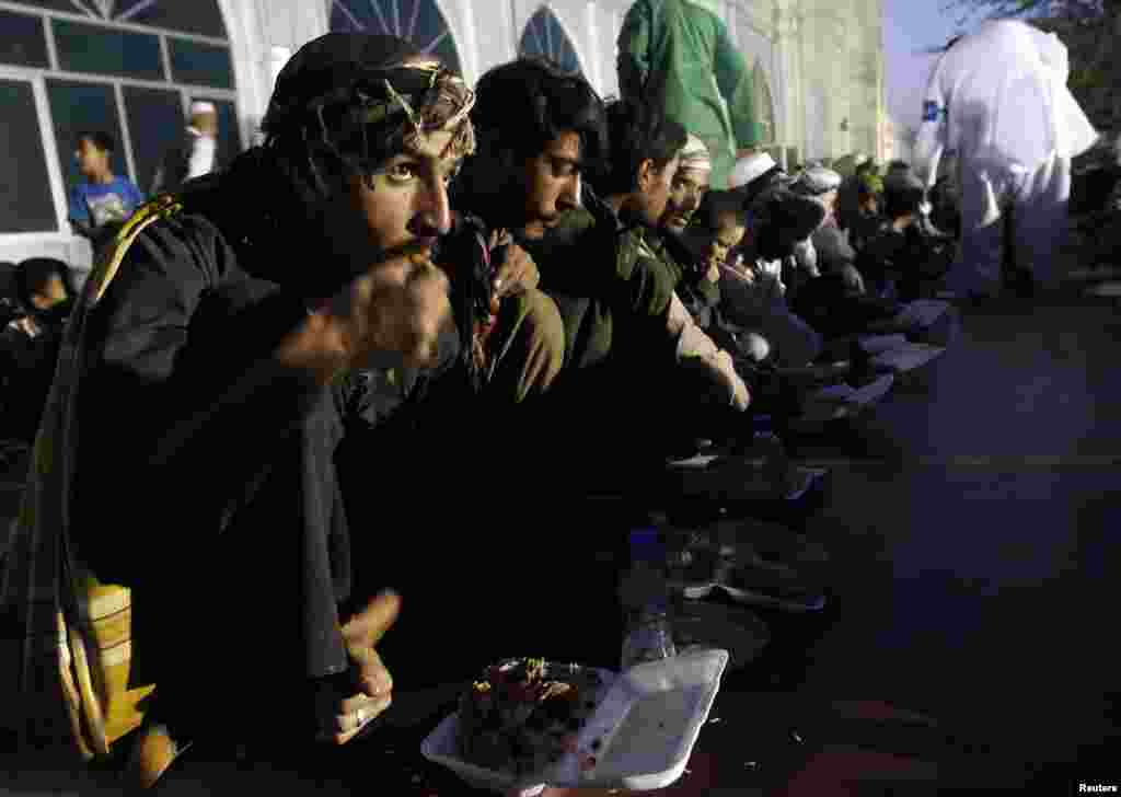 Para pria Afghan berbuka puasa di mesjid di Kabul. 