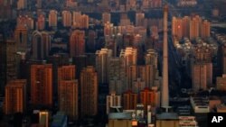 The setting sun illuminates residential buildings in eastern Beijing, as seen from the top of the China World Trade Center Tower 3