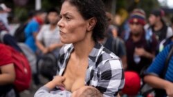 Un migrante amamanta a su bebé mientras camina con un grupo de migrantes a lo largo de una carretera con la esperanza de llegar a los distantes Estados Unidos, cerca de Agua Caliente, Guatemala.