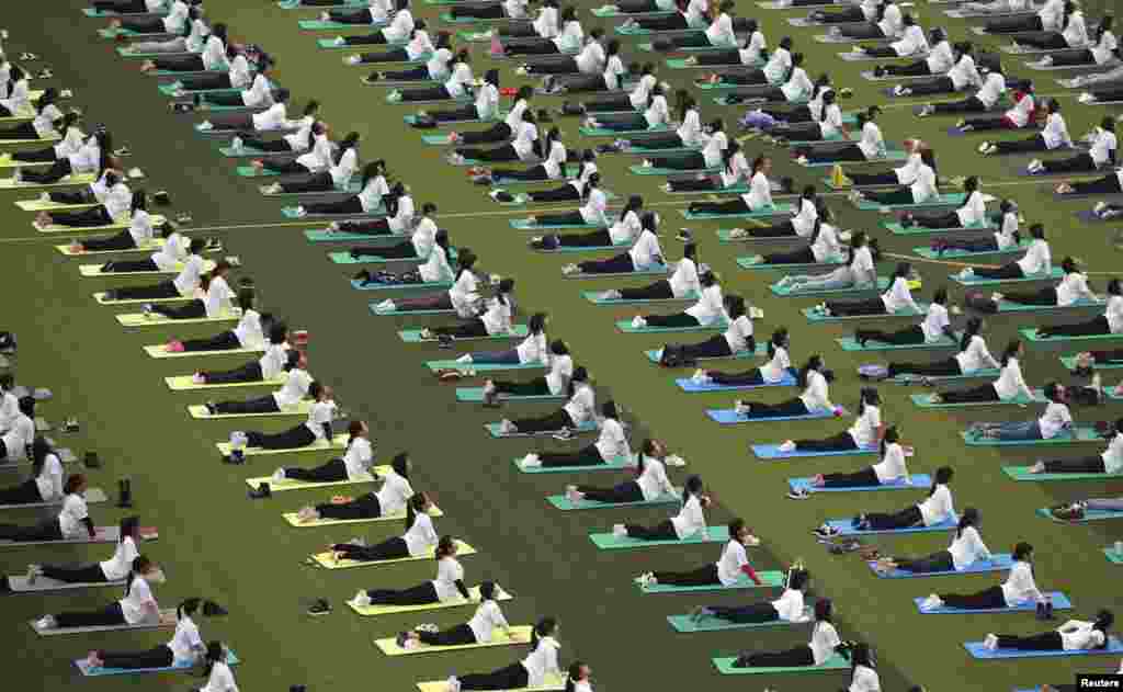 Hundreds of participants practice yoga at an event to mark the upcoming World AIDS Day, at an university in Guilin, Guangxi Zhuang Autonomous Region, China,