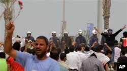 Anti-government protesters chant and wave flowers in front of riot police in Manama, Bahrain, March 13, 2011