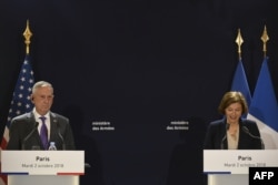 FILE - French Defense Minister Florence Parly speaks next to then-US Defense Secretary Jim Mattis during a press conference after their meeting at the French Defense ministry in Paris, Oct. 2, 2018.