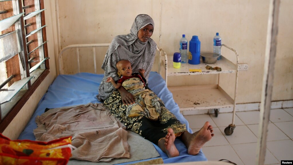 FILE - A Somali refugee holds a toddler at a hospital in the Dadaab refugee camp, Kenya, December 19, 2017.