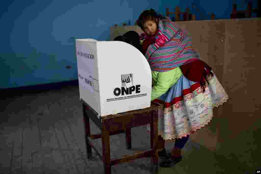 A Quechua indigenous woman casts her vote during general elections in Iquicha, Peru.