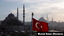 Ilustrasi - Bendera Turki, dengan latar belakang Masjid Baru dan Masjid Suleymaniye, berkibar di atas feri penumpang di Istanbul, Turki, 11 April 2019. (REUTERS/Murad Sezer)