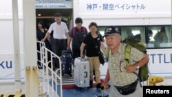 Passengers who were stranded at Kansai International Airport due to powerful typhoon Jebi are transported out by a high-speed boat at Kobe airport, in Kobe, Japan, in this photo taken by Kyodo, Sept. 5, 2018. (Kyodo/via Reuters)