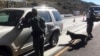 FILE - Border patrol agents use a drug-sniffing dog to check vehicles at California's Pine Valley checkpoint, on the main route from Arizona to San Diego, Dec. 14, 2017.