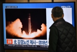 FILE - A man watches a television news program showing file footage of North Korea's missile test, at a railway station in Seoul, Jan. 1, 2020.