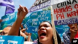 Protesters shout slogans during a rally outside of the Chinese Consulate hours before the Hague-based UN international arbitration tribunal is to announce its ruling on the South China Sea, July 12, 2016, in Makati city, east of Manila, Philippines. 