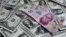 FILE - A picture illustration shows Mexican pesos and U.S. dollars banknotes in Mexico City.