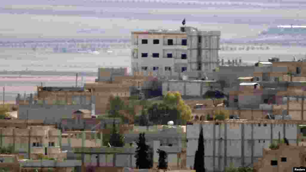 A black flag belonging to the Islamic State is seen in the Syrian town of Kobani, near the Turkish-Syrian border, Oct. 15, 2014. 
