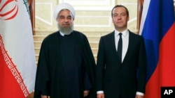 Russian Prime Minister Dmitry Medvedev, right, and Iranian President Hassan Rouhani pose for a photo during their meeting in the Gorky residence outside Moscow, Russia, March 27, 2017. 