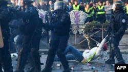 A policeman evacuates a demonstrator in Quimper, western France, during a day of nationwide protest called "yellow vest" (Gilets Jaunes in French) movement to protest against high fuel prices, Nov. 17, 2018.