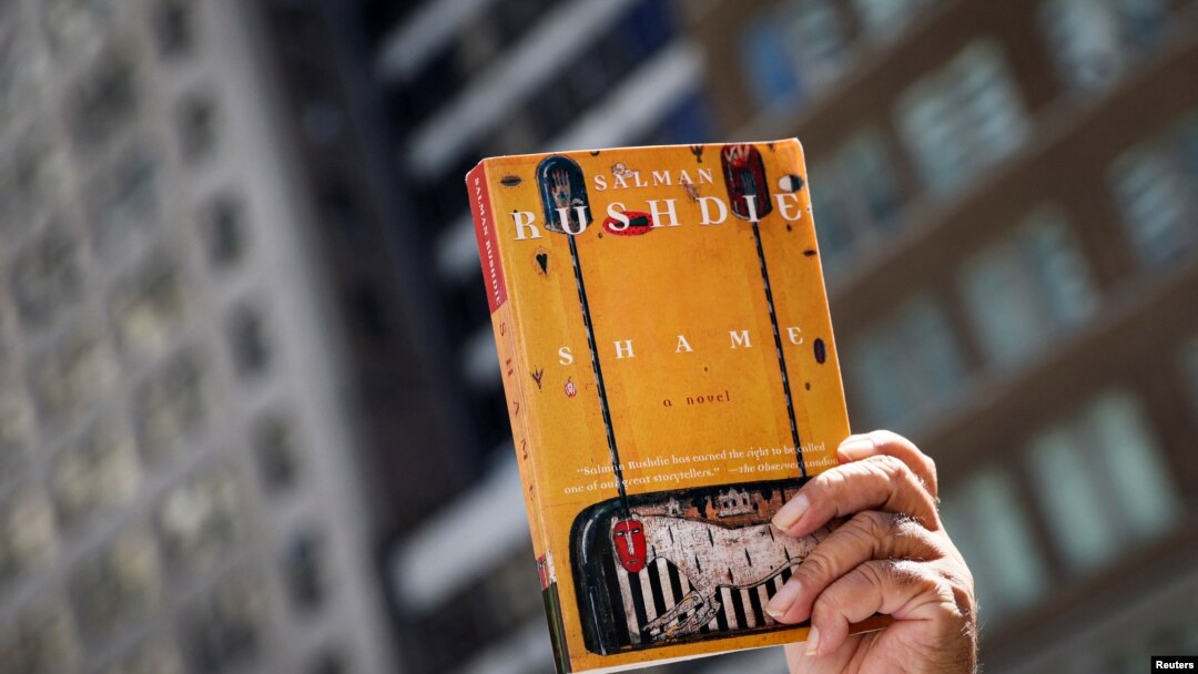 FILE - Seorang pendukung mengangkat salinan buku 'Shame' karya penulis Salman Rushdie saat berlangsungnya aksi solidaritas untuk kebebasan berekspresi di Perpustakaan Umum New York, AS, 19 Agustus 2022. (REUTERS/Brendan McDermid)