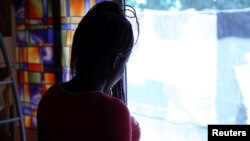 FILE - Nigerian ex-prostitute "Beauty" (a pseudonym), poses in a social support center for trafficked girls near Catania in Italy.